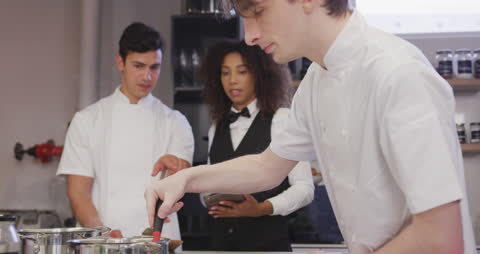 Chefs and Waitress Collaborating in Professional Kitchen