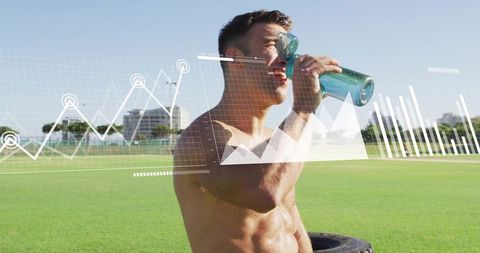 Shirtless male athlete drinking bottle on sunny sports field with performance graphs overlay