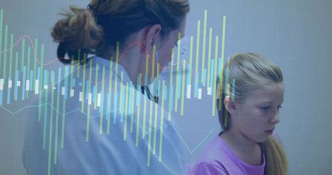 Pediatrician examining young girl with digital health charts and monitoring data