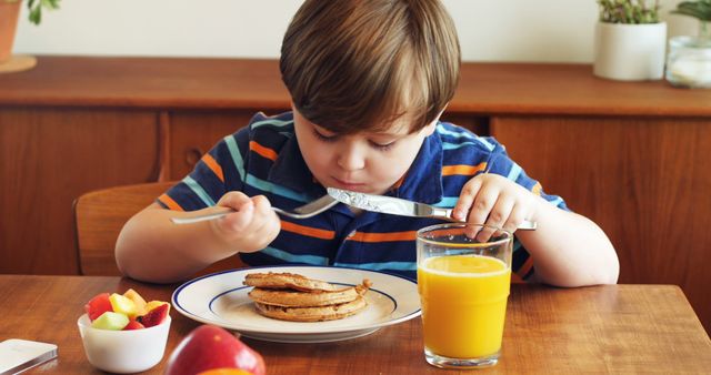 Young Boy Enjoying Pancakes Breakfast with Orange Juice - Download Free Stock Images Pikwizard.com