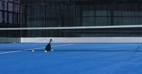 Padel Equipment on Blue Court with Racket Silhouette