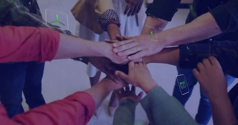 Diverse team uniting hands with renewable energy icons