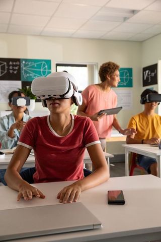 Chinese Woman Student Wearing VR Headset in Classroom with Teacher Guiding Using Tablet