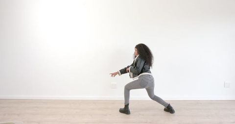 Woman in Leather Jacket Dancing Energetically in Minimalist Room
