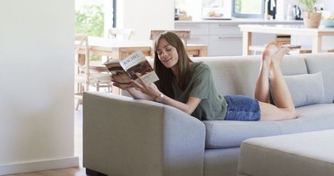Woman Relaxing on Sofa Reading a Book in Peaceful Home Setting - Download Free Stock Images Pikwizard.com