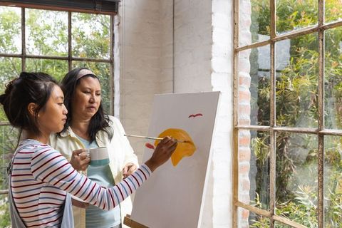 Female artists together creating art in bright studio