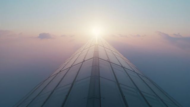 Futuristic Rooftop Spire Capturing Sunrise above Clouds