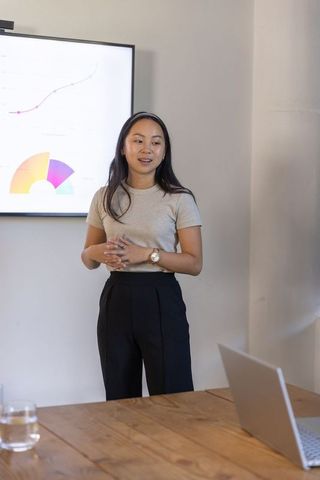 Asian businesswoman presenting data in modern office meeting