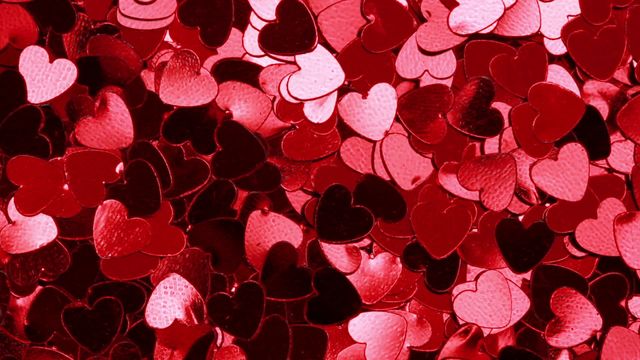 This vibrant red heart confetti creates a festive atmosphere, adding sparkle to any celebration or romantic setting like weddings, anniversaries, or Valentine's Day events. The shiny, reflective surfaces provide a lively play of color, making them perfect for party decorations, creative crafts, or backdrops for photography and social media posts.