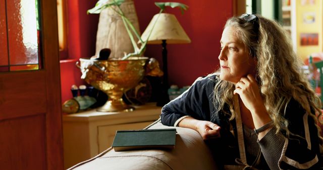 Pensive Woman Relaxing at Home with Tablet in Warm Light - Download Free Stock Images Pikwizard.com