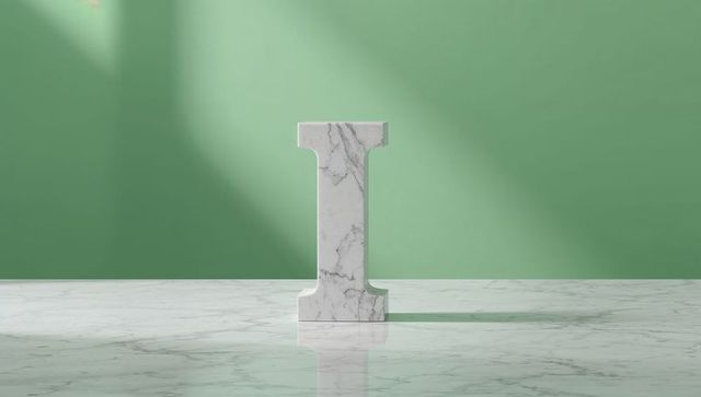 Marble Letter I Sculpture Against Light Green Backdrop