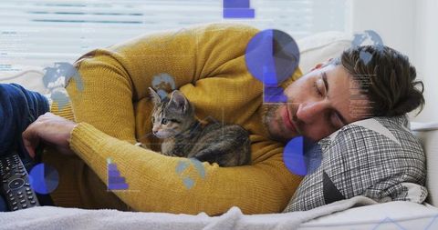 Man relaxing on sofa with tabby kitten, mustard sweater holding remote, cozy moment