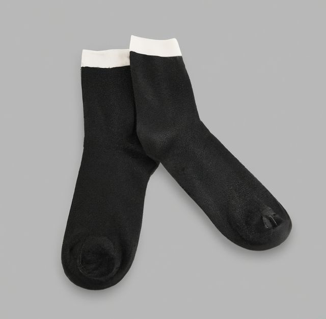 Pair of black socks laid flat against a gray background. Useful for winter clothing advertisements, online apparel stores, or promotional materials for sock brands and cozy lifestyle-themed content.