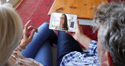Older Couple Video Calling Daughter on Tablet at Home