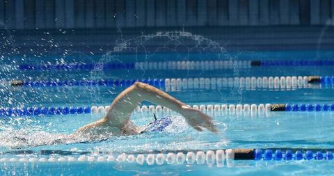 Female Swimmer Performing Front Crawl in Competition Pool, Splash Motion and Speed