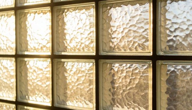 Glowing Sunlight Filtering Through Textured Glass Blocks Casting Grid Shadows