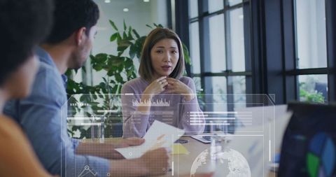 Diverse Team Engaged in Data Analysis with High-Tech Graphics