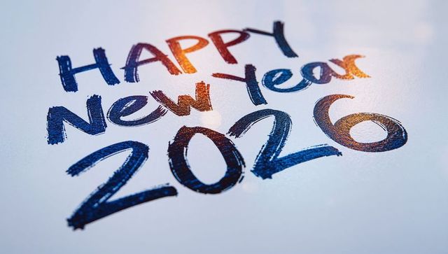 Celebrating new year 2026 with bold blue brushstroke lettering and metallic glow