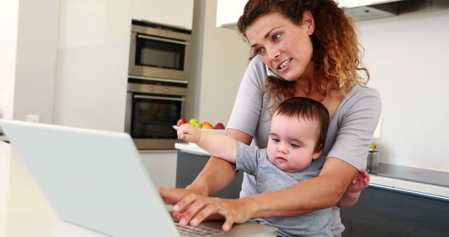 Stressed mother working from home with baby on lap multitasking - Download Free Stock Images Pikwizard.com