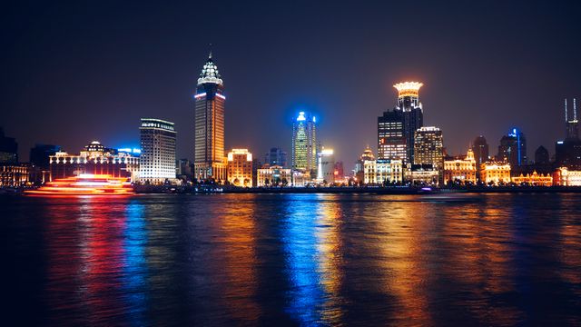 Shanghai skyline lit up beautifully at night, with colorful reflections seen on the water. Ideal for travel advertisements, urban lifestyle content, cityscape backgrounds, and articles on modern architecture. Perfect for showcasing the vibrant city life in Shanghai.