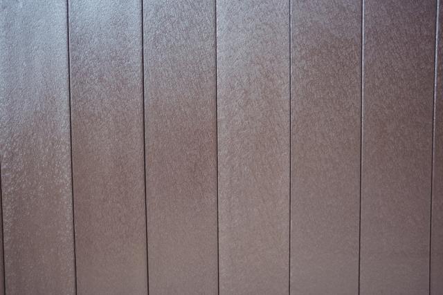 This image shows a close-up view of vertical wooden panels, providing a detailed texture and pattern. Ideal for use in interior design projects, website backgrounds, or as a backdrop in presentations. The natural brown tones and rustic feel make it suitable for themes related to construction, home decor, and natural materials.