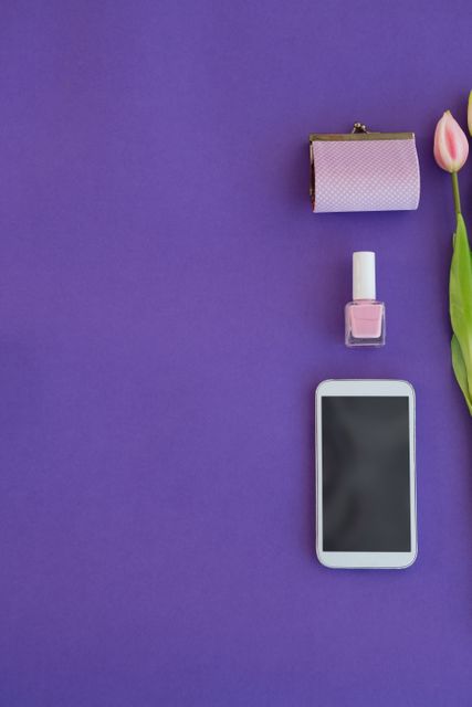 Tulips, purse, nail polish and mobile phone arranged on purple background - Download Free Stock Photos Pikwizard.com