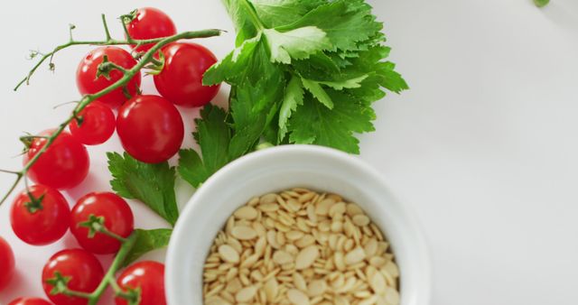 Image of fresh cherry tomatoes, parsley and seeds with copy space on white background. fusion food, fresh vegetables and healthy eating concept.