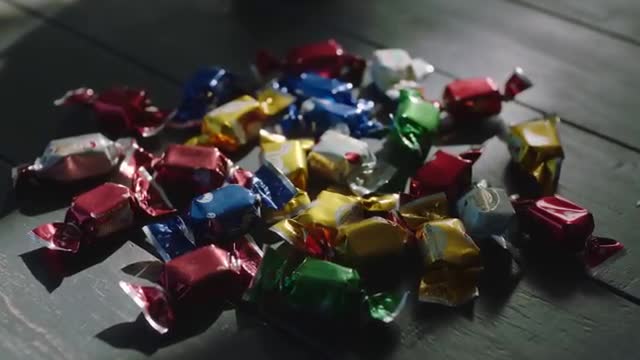 Assorted Candy Wrappers on Wooden Table: Color and Texture Play
