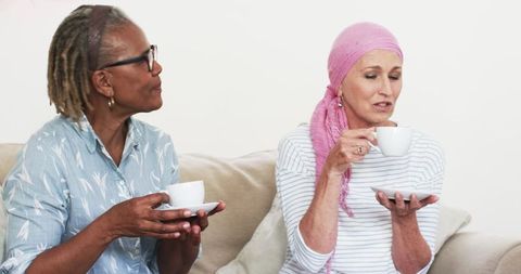 Senior Friends Sharing Coffee Discussing Cancer Recovery Journey