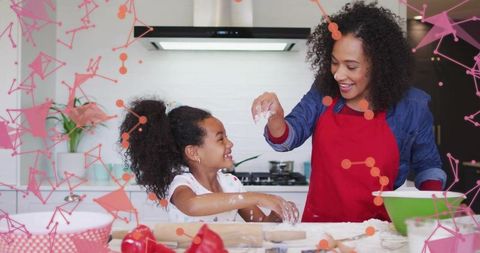 Mother and Daughter Baking Together in Bright Kitchen Laughing and Sprinkling Flour