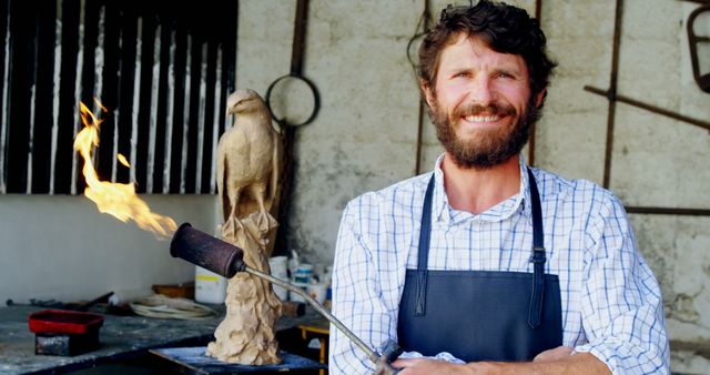 Smiling Male Artisan Creating Bird Sculpture with Blowtorch - Download Free Stock Images Pikwizard.com