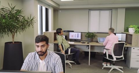 Diverse Professionals Focusing on Tasks in Modern Open-Plan Office