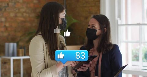 Women in office collaborating with digital devices