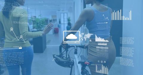 Colleagues discussing while holding bicycle with digital data overlays in modern office