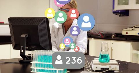 Scientist using computer with social notifications overlay and test tubes in lab