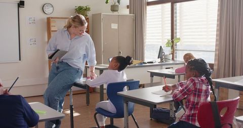 Engaging teacher interacting with diverse students in modern classroom