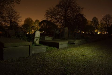Eerie nighttime cemetery with tombstones