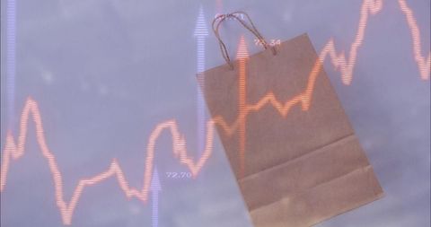 Kraft shopping bag tilting with rising financial chart overlay for retail growth concept