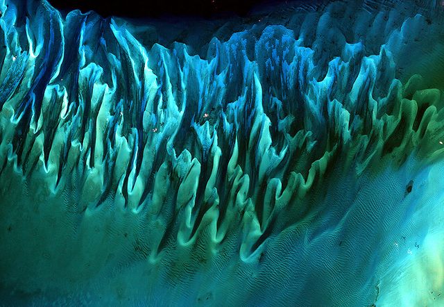 NASA image acquired January 17, 2001  Though the above image may resemble a new age painting straight out of an art gallery in Venice Beach, California, it is in fact a satellite image of the sands and seaweed in the Bahamas. The image was taken by the Enhanced Thematic Mapper plus (ETM+) instrument aboard the Landsat 7 satellite. Tides and ocean currents in the Bahamas sculpted the sand and seaweed beds into these multicolored, fluted patterns in much the same way that winds sculpted the vast sand dunes in the Sahara Desert.  Image courtesy Serge Andrefouet, University of South Florida  Instrument: Landsat 7 - ETM+  Credit: NASA/GSFC/Landsat  <b><a href="http://www.nasa.gov/centers/goddard/home/index.html" rel="nofollow">NASA Goddard Space Flight Center</a></b> enables NASA’s mission through four scientific endeavors: Earth Science, Heliophysics, Solar System Exploration, and Astrophysics. Goddard plays a leading role in NASA’s accomplishments by contributing compelling scientific knowledge to advance the Agency’s mission.  <b>Follow us on <a href="http://twitter.com/NASA_GoddardPix" rel="nofollow">Twitter</a></b>  <b>Join us on <a href="http://www.facebook.com/pages/Greenbelt-MD/NASA-Goddard/395013845897?ref=tsd" rel="nofollow">Facebook</a></b>