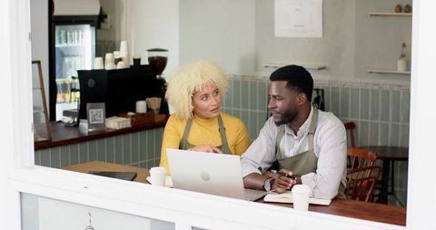 Cafe Business Planning with Laptop Discussion