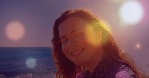 Smiling Woman by the Ocean During Serene Sunset