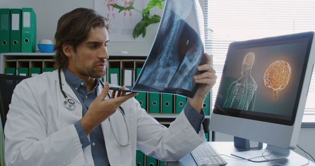 Doctor Examining X-Ray Image Speaking into Dictaphone in Modern Medical Office - Download Free Stock Images Pikwizard.com