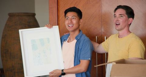 Diverse Couple Admiring Art While Moving Into New Home
