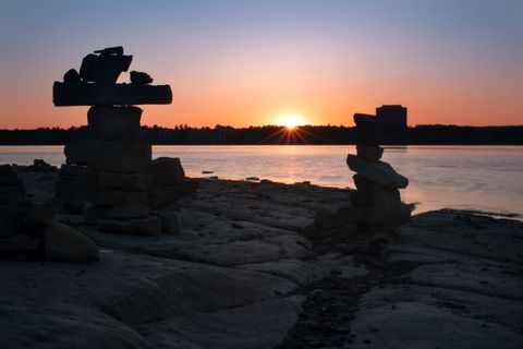 Tranquil Lakeside Sunrise with Rock Balancing