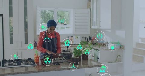 Headwrap chef preparing eggs at sunlit modern kitchen island with green energy icons