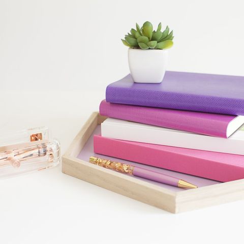 Stylish purple office supplies like books with succulent plant