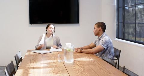 Colleagues discussing project in modern meeting room