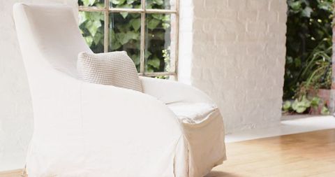 Cozy slipcovered armchair in bright sunlit room