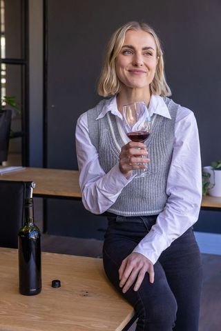 Elegant Woman Savoring Red Wine in Stylish Tasting Room