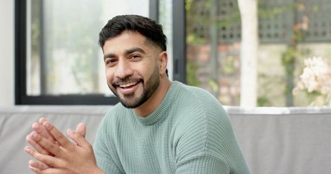 Smiling Man in Cosy Living Room Near Large Window